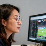 体育媒体编辑李女士的职业头像，戴着眼镜在电脑前认真工作的侧脸。